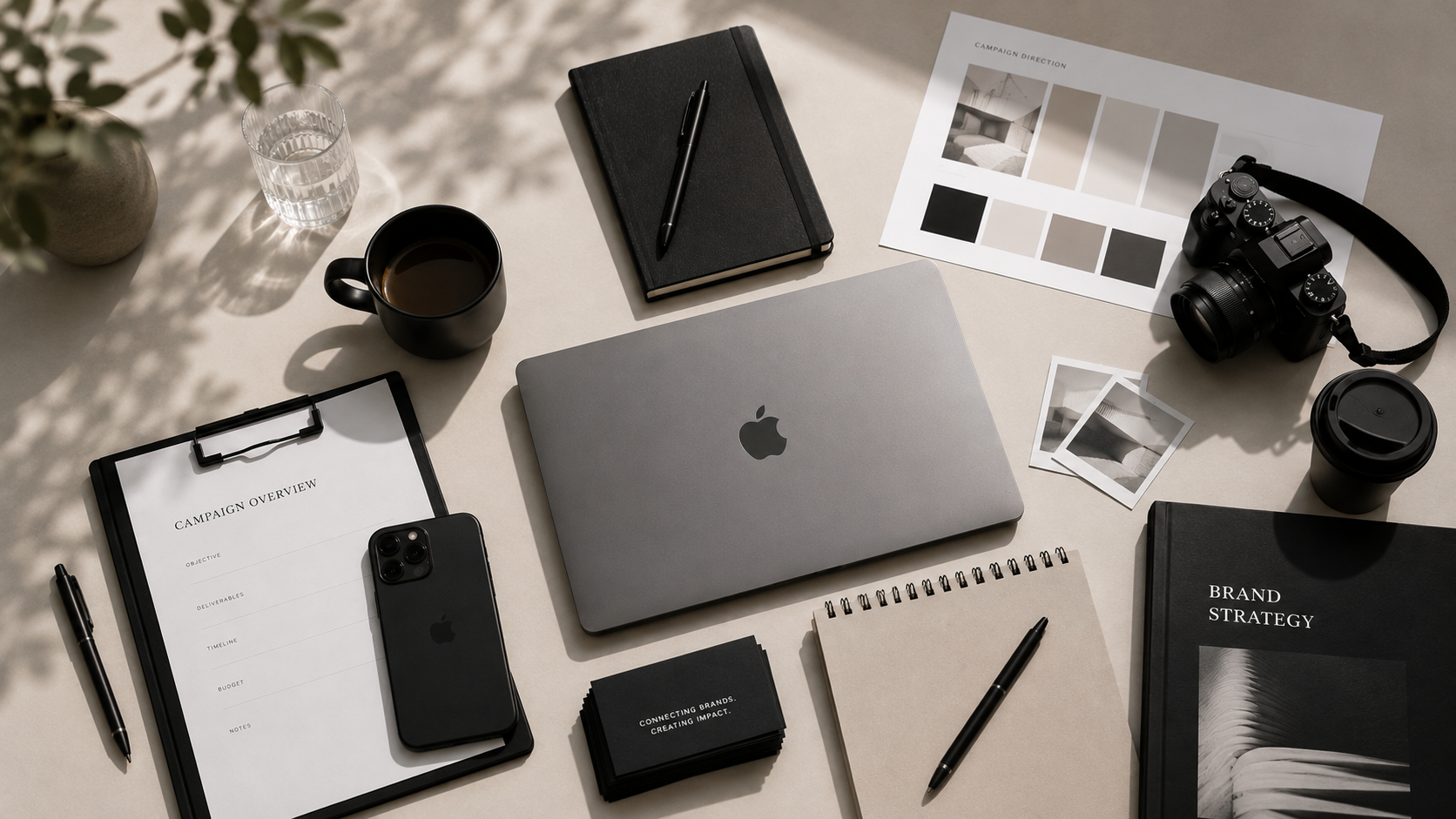 Creator reviewing campaign content on a phone with laptop and coffee nearby
